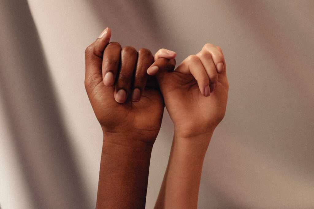 Zwei Frauenhände mit unterschiedlichen Hautfarben - queere Menschen und BIPoC sind in meiner Praxis für Paarberatung willkommen.